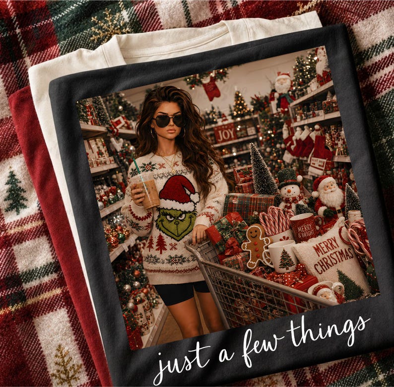 May include: A black t-shirt featuring a graphic print of a person wearing a Grinch-themed sweater and sunglasses, standing in a store aisle filled with Christmas decorations and a shopping cart. The text "just a few things" is printed at the bottom.