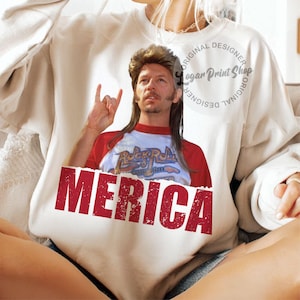 May include: White sweatshirt featuring a red, white and blue graphic of a man with long blonde hair and a goatee. The graphic says "Rock & Roll" and "Merica".