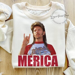 May include: A white t-shirt featuring a red, white and blue graphic of a man with long hair and a moustache. The man is wearing a red and white baseball jersey with the words "Rock & Roll" on it. The text "MERICA" is printed in red at the bottom of the shirt.