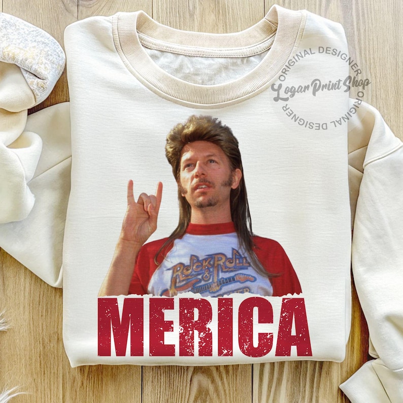 May include: A white t-shirt featuring a red, white and blue graphic of a man with long hair and a moustache. The man is wearing a red and white baseball jersey with the words "Rock & Roll" on it. The text "MERICA" is printed in red at the bottom of the shirt.