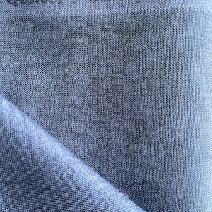 May include: Close-up of a folded piece of blue fabric with the text "Quilter's Candy Shop" printed across the top. The fabric has a textured appearance and is folded at an angle, revealing a lighter shade of blue.