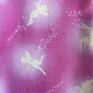 May include: Close-up of a fabric with a pink and white gradient background. Silhouettes of fairies are scattered across the fabric, with trails of small stars. The fabric has a textured appearance.