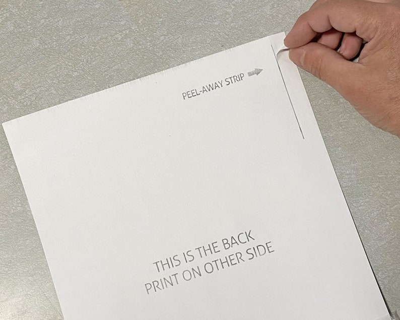 May include: A white sheet of paper with a peel-away strip at the top. The text "PEEL-AWAY STRIP" is printed above the strip. The text "THIS IS THE BACK PRINT ON OTHER SIDE" is printed at the bottom of the sheet.