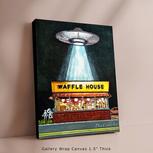 Puede incluir: Una pintura de acuarela de un OVNI flotando sobre un restaurante Waffle House por la noche. El OVNI emite una luz brillante que ilumina el restaurante. Dos figuras alien&iacute;genas est&aacute;n de pie fuera del restaurante. La pintura est&aacute; firmada "Don Cobb Art".