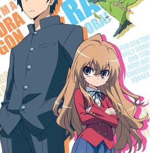 Peut inclure: Illustration d'anime de deux personnages, une fille aux longs cheveux bruns portant une veste rouge et une jupe bleue, et un gar&ccedil;on aux cheveux bleus portant une veste bleu fonc&eacute;. La fille est debout, les bras crois&eacute;s, avec une expression s&eacute;rieuse. Le gar&ccedil;on est debout derri&egrave;re elle avec une expression neutre. L'arri&egrave;re-plan est un motif color&eacute; avec le texte "To ra do ra" en grandes lettres.