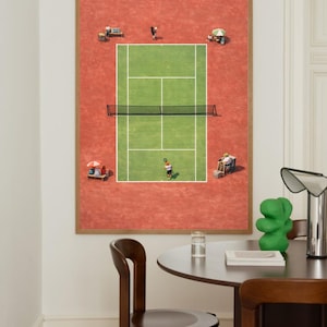Op de afbeelding: Een ingelijste print van een tennisbaan, gezien van bovenaf, met spelers en toeschouwers. De groene baan is afgezet tegen een rode achtergrond. Verschillende kleine figuren zijn verspreid rond de baan, sommige onder parasols.