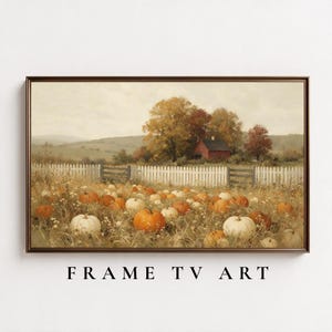May include: A landscape painting in a dark frame depicting a field of orange and white pumpkins in front of a white picket fence. A red house sits among autumn trees in the background under a cloudy sky. The text FRAME TV ART appears below.
