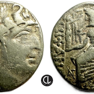 Puede incluir: Dos monedas antiguas de plata. Una moneda presenta el perfil de una persona con detalles capilares y faciales. La otra moneda representa una figura sosteniendo un bastón, con intrincados detalles de fondo. Ambas monedas muestran desgaste.