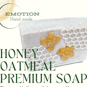 May include: A white bar of soap with a honeycomb design and two yellow bees. The soap is labeled "Honey Oatmeal Premium Soap" and "Emotion Hand Made".