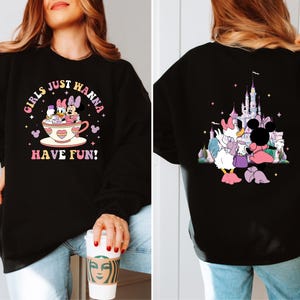 May include: Black sweatshirt with a graphic print of Mickey Mouse and Minnie Mouse in a teacup with the text "Girls Just Wanna Have Fun!" on the front and a graphic print of Mickey Mouse and Minnie Mouse in front of a castle on the back.