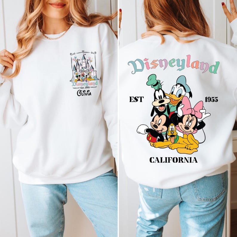 May include: White sweatshirt with a colorful Disneyland graphic on the front and a larger graphic on the back featuring Mickey Mouse, Minnie Mouse, Donald Duck, Goofy, and Pluto. The back graphic also includes the text "Disneyland", "EST 1955", and "CALIFORNIA".