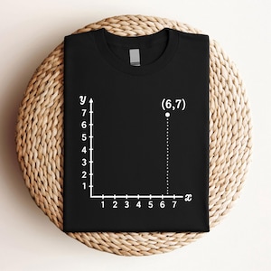 May include: Black t-shirt featuring a white graph with x and y axes, and the coordinates (6,7). The shirt is a classic crew neck style, perfect for casual wear. The design is simple and clean, making it a versatile addition to any wardrobe.