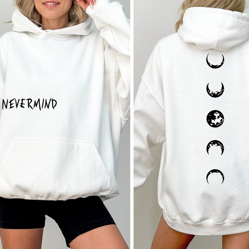 May include: White hoodie with a front pocket and the word "NEVERMIND" printed in black. The back of the hoodie features a series of moon phase graphics in black. A casual, comfortable garment.