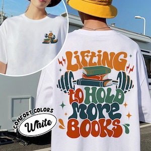 May include: White t-shirt with a graphic of a barbell with books on it and the text "Lifting to hold more books".
