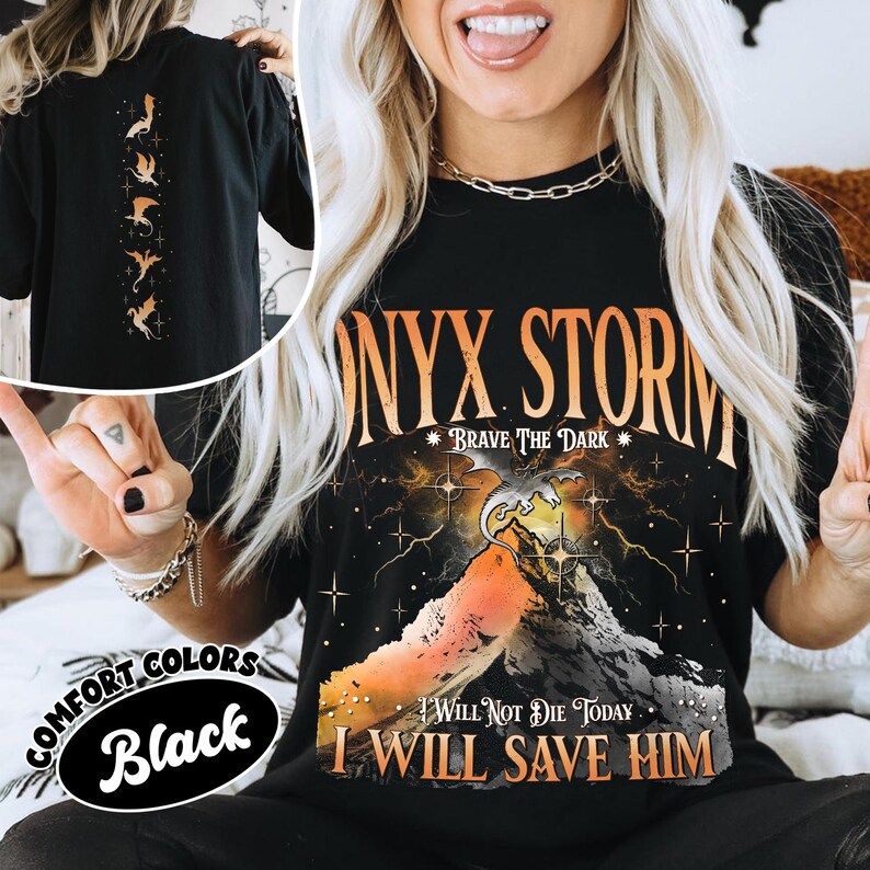May include: Black t-shirt with the text "NYX STORM" in orange and a graphic of a mountain with a dragon. The shirt also has the text "I WILL NOT DIE TODAY. I WILL SAVE HIM." The back of the shirt has a design of dragons.
