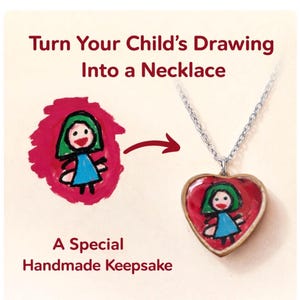 Op de afbeelding: Een ketting met een hartvormige hanger met een kindertekening. De tekening toont een figuur met groen haar en een blauwe jurk. Tekst luidt: "Verander de tekening van uw kind in een ketting" en "Een speciaal handgemaakt aandenken."