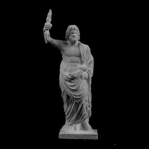 Puede incluir: Estatua gris de una figura masculina, posiblemente Zeus, sosteniendo una antorcha en alto. La estatua está cubierta con túnicas clásicas y se alza sobre una base rectangular. El fondo es negro liso.