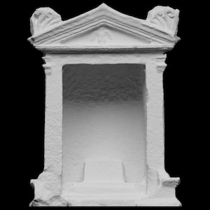 Könnte beinhalten: Eine weiße, klassisch gestaltete Architekturstruktur mit rechteckiger Öffnung. Die Struktur weist einen dreieckigen Giebel mit dekorativen Schnitzereien und einen detaillierten Fries auf. Der Innenraum ist schattiert, und die Basis hat eine Stufe.