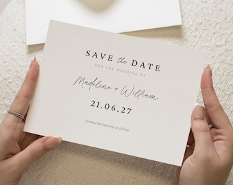 Könnte beinhalten: Eine cremefarbene "Save the Date"-Karte, gehalten von Händen, mit schwarzem Text. Die Karte lautet oben "SAVE the DATE", gefolgt von "FOR THE WEDDING OF" und den Namen "Madeline + William". Das Datum "21.06.27" steht unter den Namen, mit "formal invitation to follow" unten.