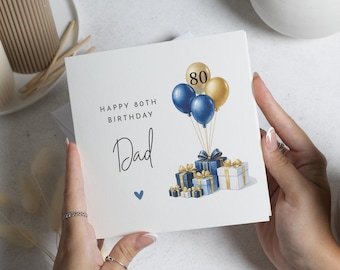 May include: A white birthday card with the text "Happy 80th Birthday Dad" in black script. The card features blue and gold balloons with the number 80, and wrapped gifts in blue and gold.