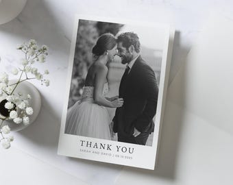 May include: Black and white wedding thank you card with a photo of a bride and groom. The text on the card reads "Thank You" with the names "Sarah and David" and the date "08.10.2023".