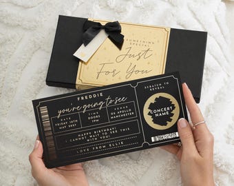 May include: A black gift box with a gold label reading Something Special Just For You and a black ribbon, paired with a black concert ticket card featuring gold text, a scratch-to-reveal circle, and details for Freddie at O2 Apollo Manchester.