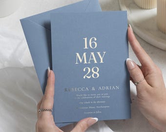 Invitaciones de boda con detalles en lámina dorada, invitación de boda minimalista en azul empolvado, invitación con tipografía elegante, papelería de boda personalizada.