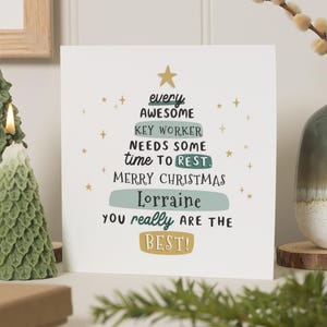 Könnte beinhalten: Eine Weihnachtskarte mit einem Tannenbaum-Design und dem Text "every AWESOME KEY WORKER NEEDS SOME time TO REST. MERRY CHRISTMAS Lorraine YOU really ARE THE BEST!" Zwei grüne baumförmige Kerzen sind links angezündet.
