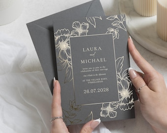 Invitaciones de boda botánicas con detalles en lámina de oro, invitación de boda floral en gris carbón, papelería elegante para bodas en el jardín.