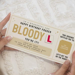 Könnte beinhalten: Ein Geburtstagsgutschein mit dem Text "BLOODY L YOU'RE 17!!" in goldfarbenen Buchstaben. Der Gutschein enthält auch den Text "10 Fahrstunden" und "Auf geht's auf die Straße!"