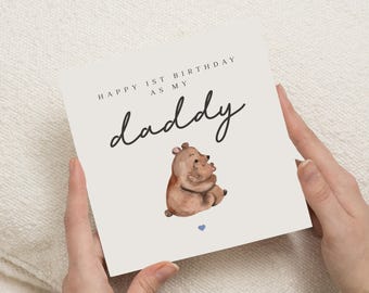 Op de afbeelding: Vierkante kaart met de tekst "HAPPY 1ST BIRTHDAY AS MY daddy" in zwart. Het toont een aquarel illustratie van twee bruine beren die elkaar omarmen, met een klein blauw hartje eronder.