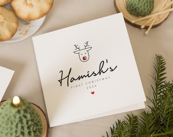 May include: A white card with a red-nosed reindeer illustration and the text "Hamish's First Christmas 2024".