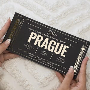 Könnte beinhalten: Eine schwarz-weiße Einladung im Stil einer Bordkarte mit dem Wort "PRAGUE" in großen, fetten Buchstaben. Die Einladung enthält Details wie Datum, Uhrzeit und Abflughafen sowie den Namen "Ollie". Der Text lautet "Pack deine Taschen! Du gehst nach..." und "Alles Gute zum 18. Geburtstag".