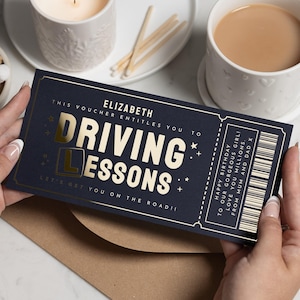 Puede incluir: Un vale de regalo azul marino para clases de conducir, sostenido por una persona. El vale tiene letras doradas que dicen "Driving Lessons" e incluye el nombre del destinatario, "Elizabeth". El vale también tiene un mensaje de cumpleaños.
