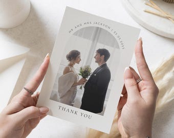 May include: A wedding thank you card with a photo of a bride and groom in a white dress and black suit. The card has a white background with a gray circle around the photo and the text "Mr. and Mrs. Jackson | 25.05.2025" and "Thank You".