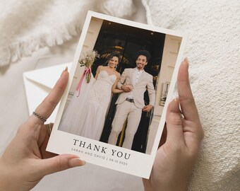 May include: A cream-colored thank you card with a photograph of a smiling couple. The card reads "THANK YOU" with the names "Sarah and David" and the date "08.10.2025" below. The card is held by a person.