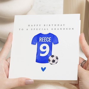 May include: A white birthday card with the message "HAPPY BIRTHDAY TO A SPECIAL GRANDSON." The card shows a blue football shirt with "REECE" and the number "9," a football, and a blue heart.