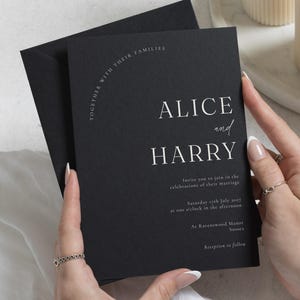 Könnte beinhalten: Eine schwarze Hochzeitseinladungskarte mit weißem Text: Together with their families, Alice and Harry invite you to join in the celebrations of their marriage, Saturday 17th July 2027 at one o'clock in the afternoon, at Ravenswood Manor, Sussex, reception to follow.