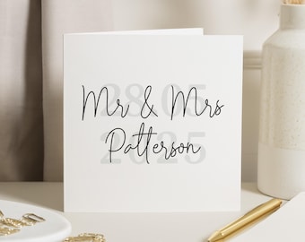 Op de afbeelding: Witte kaart met zwarte tekst die "Mr. & Mrs. Patterson" in een cursief schrift leest.