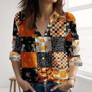 Könnte beinhalten: Ein langärmliges Button-Down-Hemd mit einem Patchwork-Design mit Halloween-Motiven. Das Muster des Hemdes umfasst Kürbisse, schwarze Katzen, Fledermäuse, Skelette und Spinnennetze in Orange, Schwarz, Weiß und Creme.
