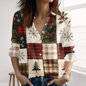 Könnte beinhalten: Ein Hemd mit Knopfleiste und Patchwork-Design mit weihnachtlichen Mustern. Das Hemd hat einen V-Ausschnitt und lange Ärmel. Zu den Mustern gehören Schneeflocken, Weihnachtsbäume und Karomuster in Rot, Grün und Weiß.
