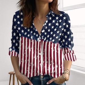 Könnte beinhalten: Langärmliges Button-Down-Shirt mit patriotischem Design. Der obere Teil ist marineblau mit weißen Sternen, die in rot-weiße Streifen übergehen. Das Hemd hat einen klassischen Kragen und einen Knopfverschluss.