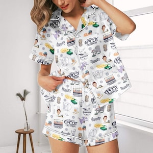 May include: White pajama set with a print featuring various characters and icons. The short-sleeved top and shorts are adorned with images of characters, the EPCOT Center logo, and the text "Guardians of the Galaxy".
