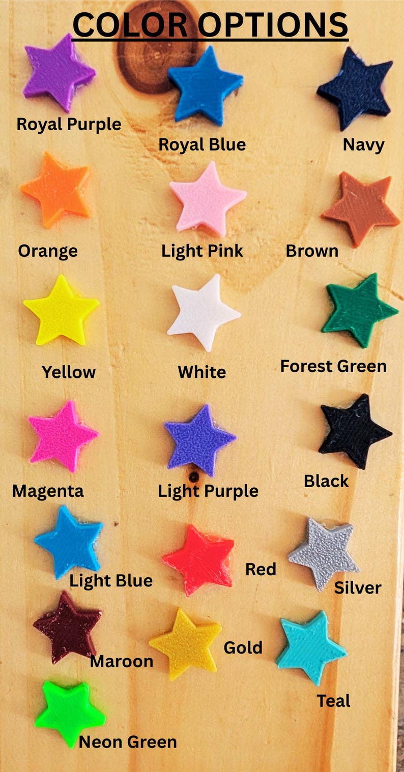 May include: Color options for a product, shown as a collection of 15 star-shaped plastic pieces in various colors, including royal purple, royal blue, navy, orange, light pink, brown, yellow, white, forest green, black, magenta, light purple, red, light blue, silver, gold, maroon, neon green, and teal.