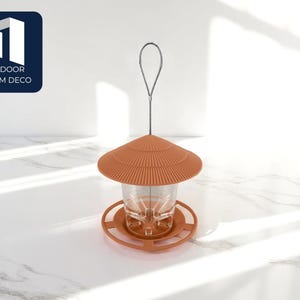 May include: A terracotta-colored bird feeder with a clear glass container and a circular base. The feeder has a decorative, ridged roof and a metal hanging loop. The text "OUTDOOR CHARM DECO" is in a navy blue square.