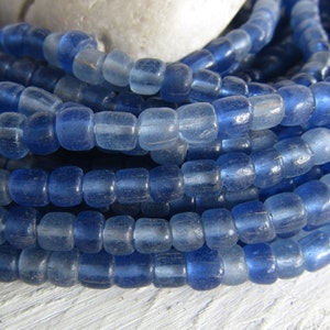 Può includere: Una collana di perline di vetro blu chiaro. Le perline sono opache e hanno una finitura leggermente opaca.