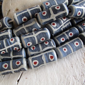 May include: A strand of blue and white ceramic beads with red accents. The beads are cylindrical and have a geometric pattern.