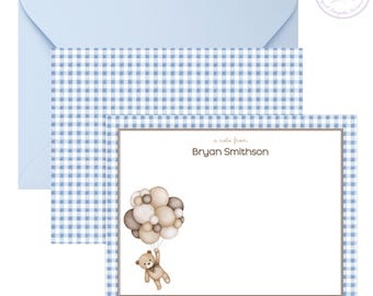 May include: Stationery set featuring a light blue envelope, a note card, and a matching patterned card. The note card has a brown border and the text "a note from Bryan Smithson". A teddy bear illustration is holding balloons.