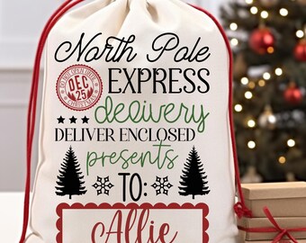 May include: A white canvas Santa sack with red drawstring, featuring the text "North Pole Express delivery" and "Deliver Enclosed Presents To: Allie".
