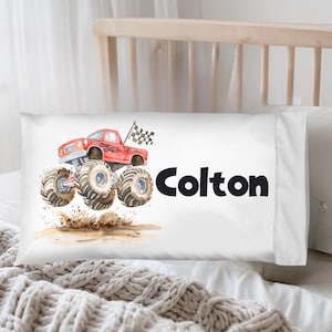 May include: White pillowcase featuring a watercolor illustration of a red monster truck with large tires, a checkered flag, and the name "Colton" in black lettering. The truck is kicking up dirt.